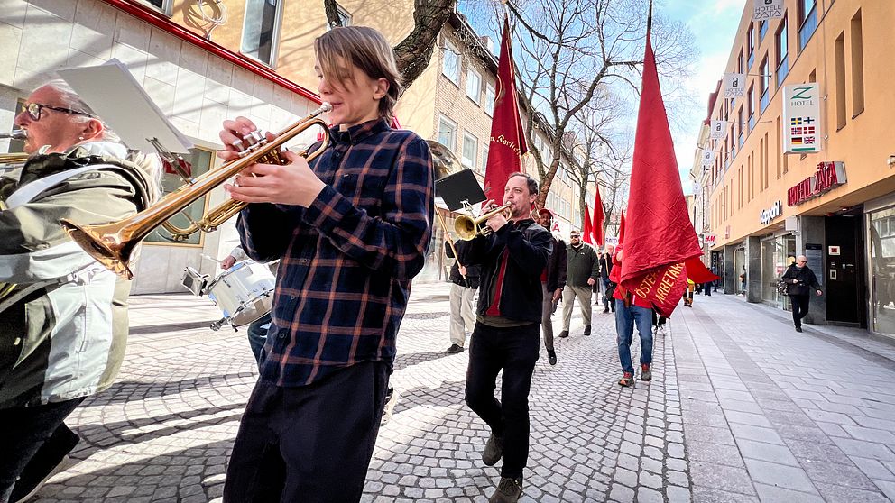 Trumpetare går i förstamajtåg genom Östersunds stadskärna.