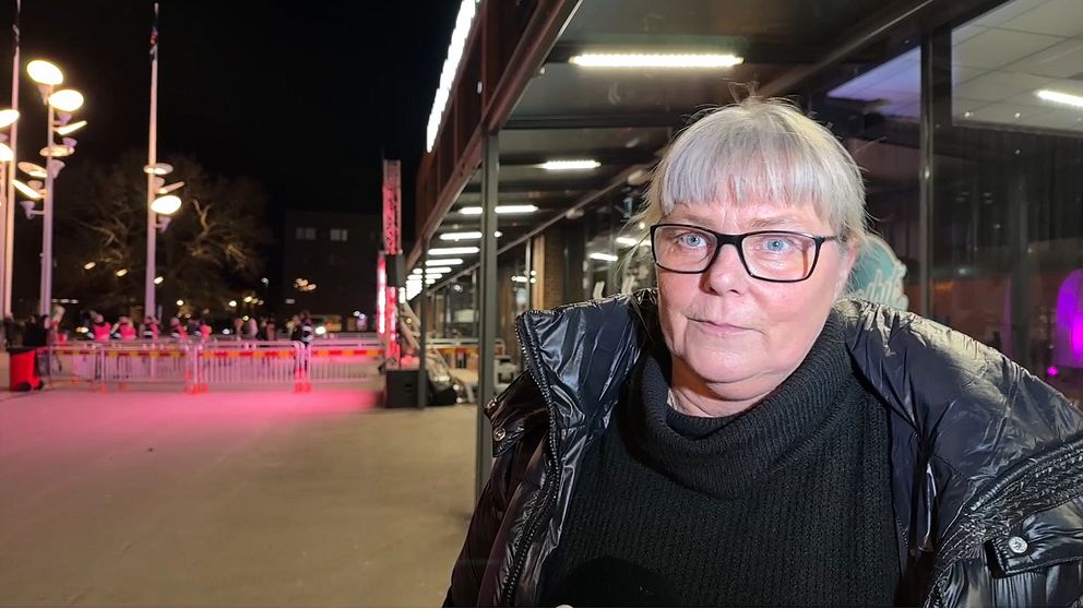 Kvinna tittar in i kameran, står utanför Volvo CE arena