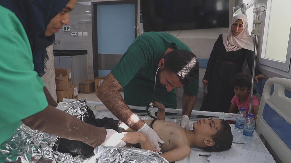 En läkare på ett sjukhus i Gaza undersöker ett barn som skadats.