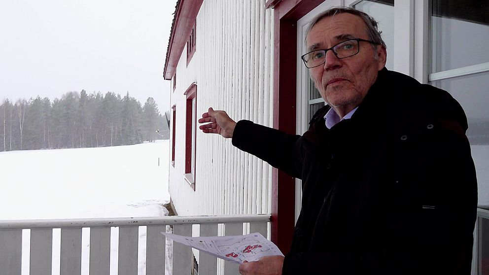 Peter Malmström i Kannusjärvi står vid sitt hus och pekar ut mot var vindkraftsverken planeras byggas.