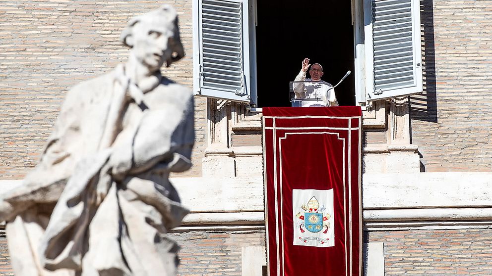 Påve Franciskus vinkar från ett fönster.