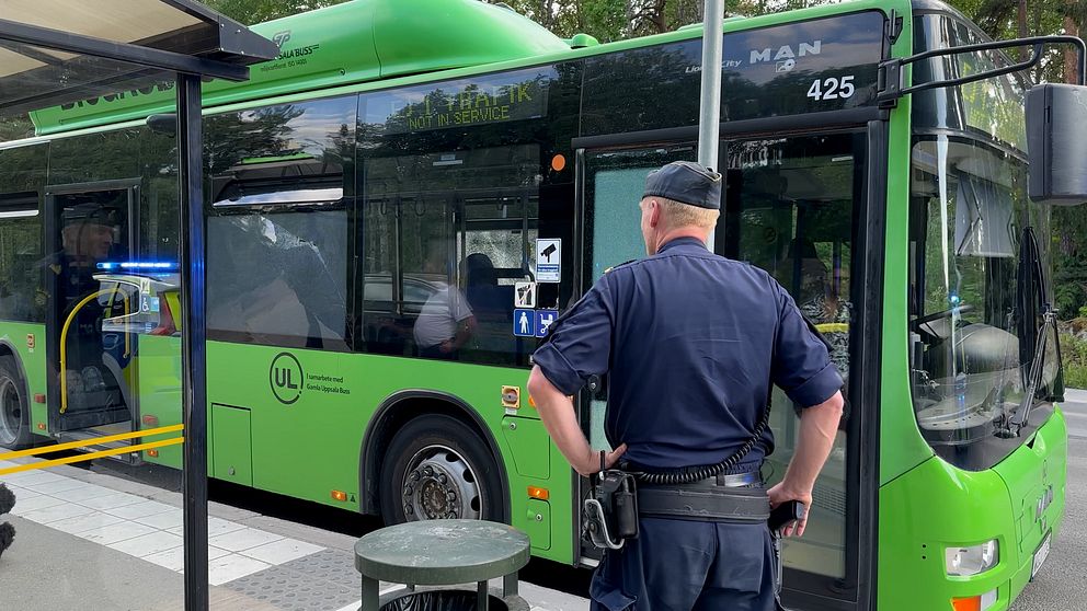 Polis står framför en buss vars fönster skadats i skjutningen