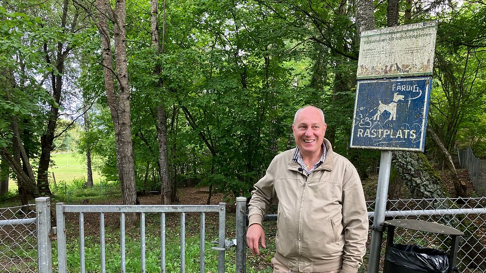 Parkchef Pierre Persson ser glad ut när han står framför en hundrastgård