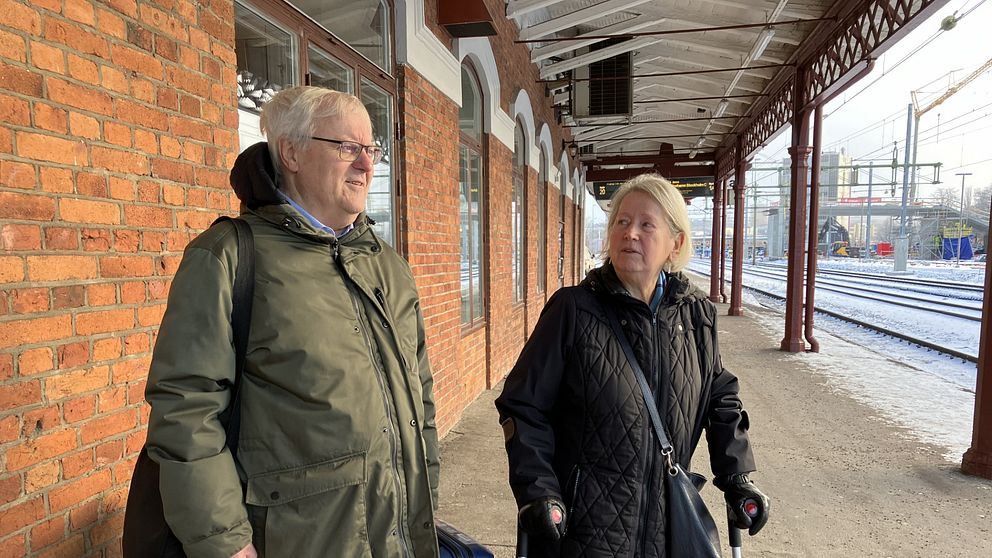 man och kvinna väntar på tågperrong