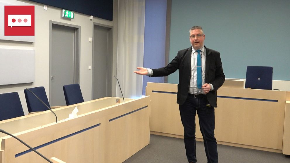 Ola Depui på Jönköpings tingsrätt står i en rättssal och pekar med handen mot sittplatserna.