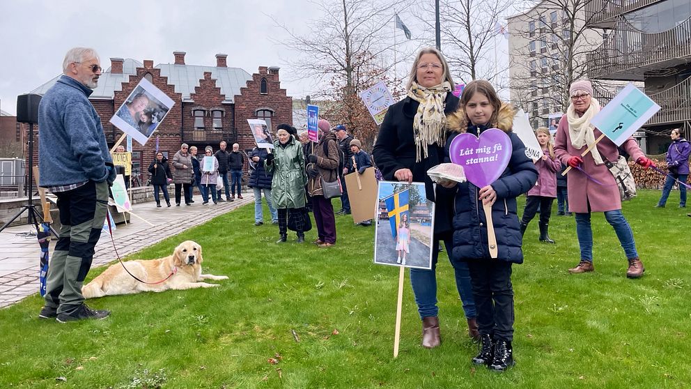 En kvinna och en flicka står mitt i en manifestation