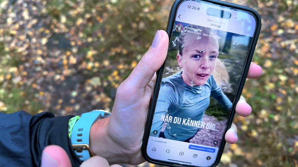 En hand som håller en mobiltelefon som visar ett Instagram-inlägg med en text som säger ”NÄR DU KÄNNER DIG...”. Bakgrunden består av höstlöv och naturlandskap.