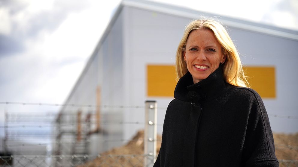 Blond kvinna står framför byggprojekt