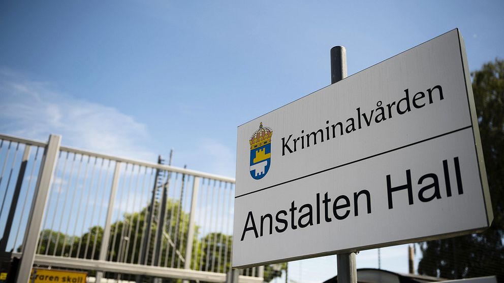 Skylt på kriminalvårdens anstalt Hall under blå himmel