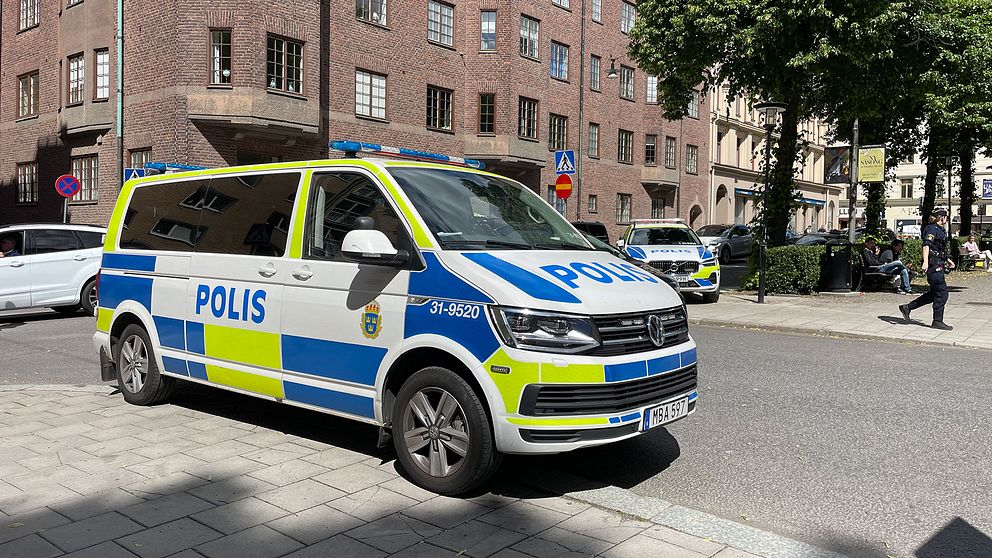En polisbil framför en tegelbyggnad på Kungsholmen.