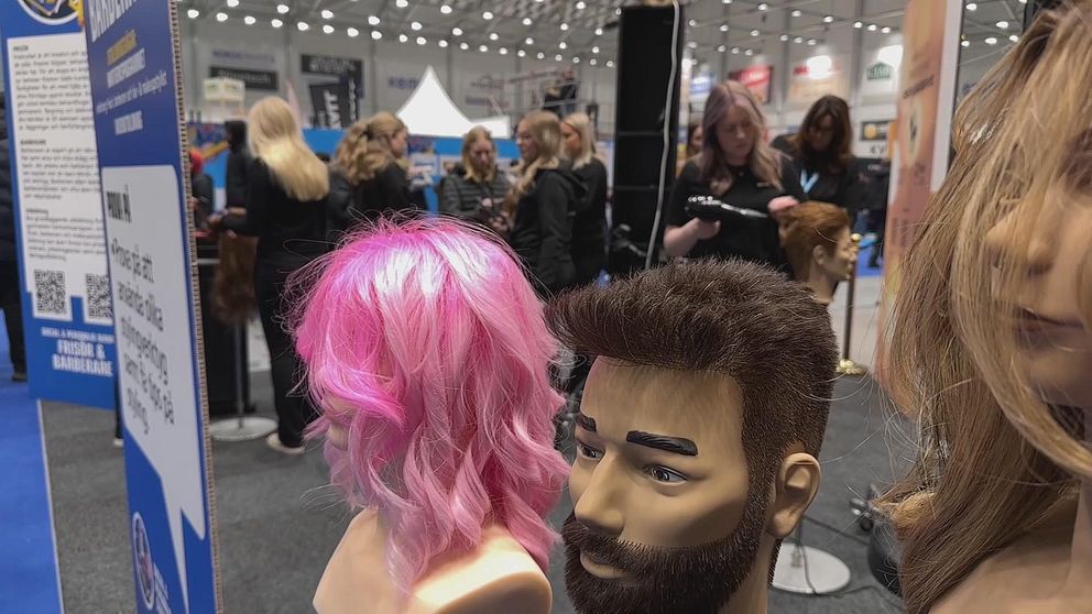 dockor med peruker framför frisörer som tävlar i Yrkes-SM