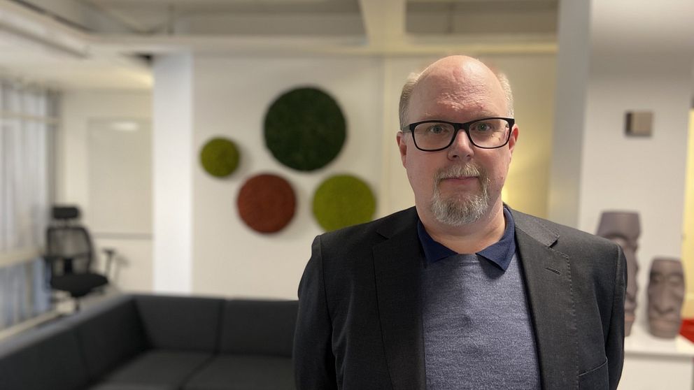 Thomas Gustafsson (S) står i en kontorsmiljö och tittar in i kameran.