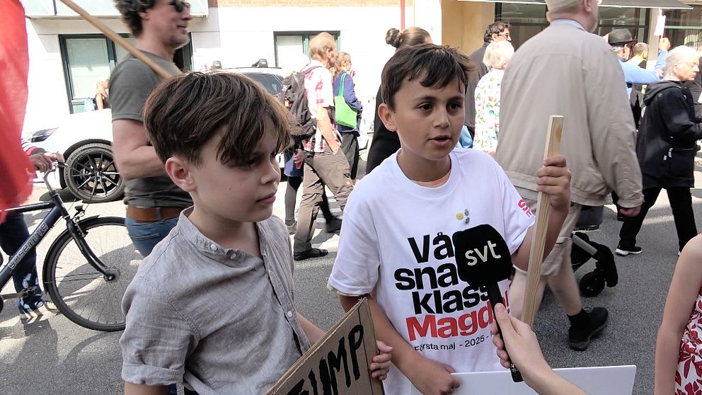 Två ungdomar på 1:a maj demonstration intervjuas av SVT-reporter bland andra deltagare på gatan.