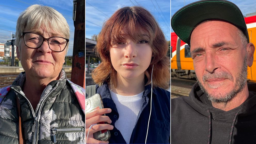 Tre personer står på en station, omgivna av tåg och stationselement. Den första personen har grått hår och bär en mörk väst. Den andra personen har och brunt, lockigt hår och håller en telefon. Den tredje personen, med en keps, står nära ett orange tåg. Ljuset är klart och vädret verkar vara fint.