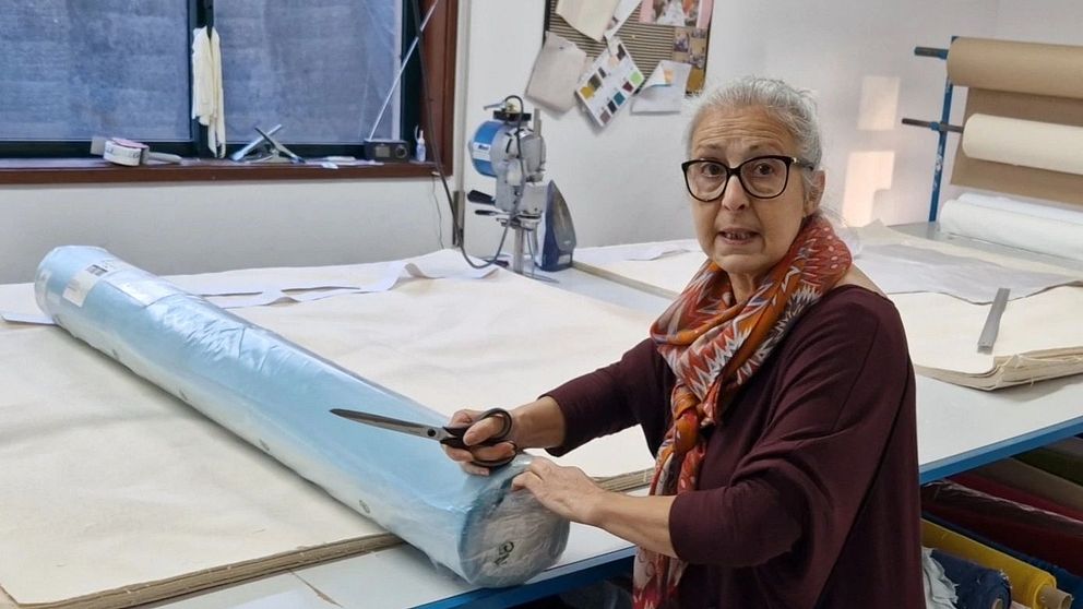Fabriksägaren Cristina Miranda håller i ett blått tyg.