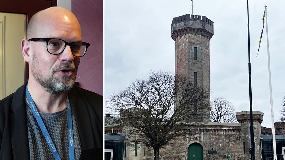 Till vänster syns en persons övre del med en mörk jacka och en namnbricka. Till höger visas en gammal stenbyggnad med en tornliknande struktur, omgiven av träd och flaggor.