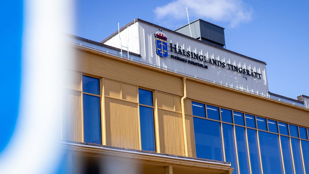 Fasad på Hälsinglands tingsrätt under klarblå himmel.