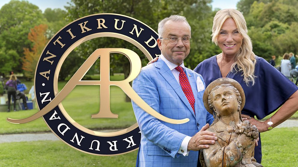 Antikrundan-logotypen bakom en man och kvinna med en antik staty i en park.