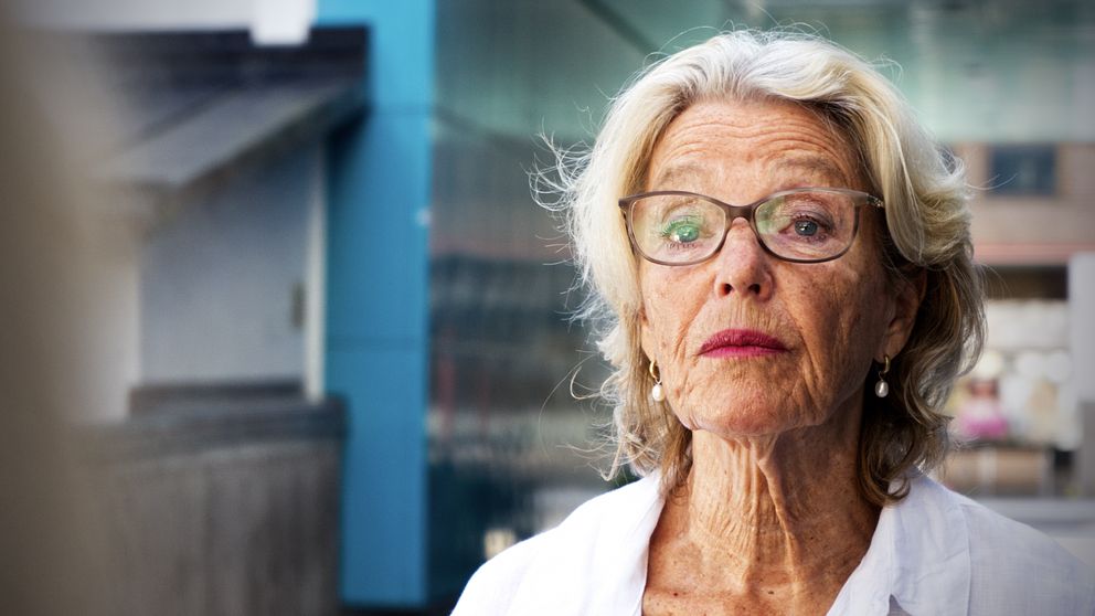 kvinna med glasögon med livlig stad i bakgrunden