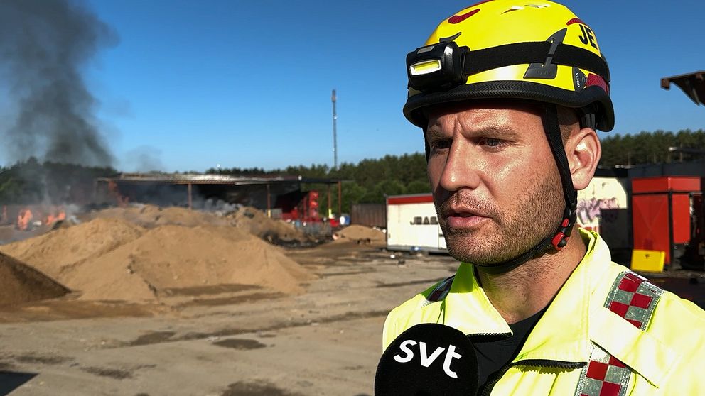 Brandman intervjuas framför brandhärd