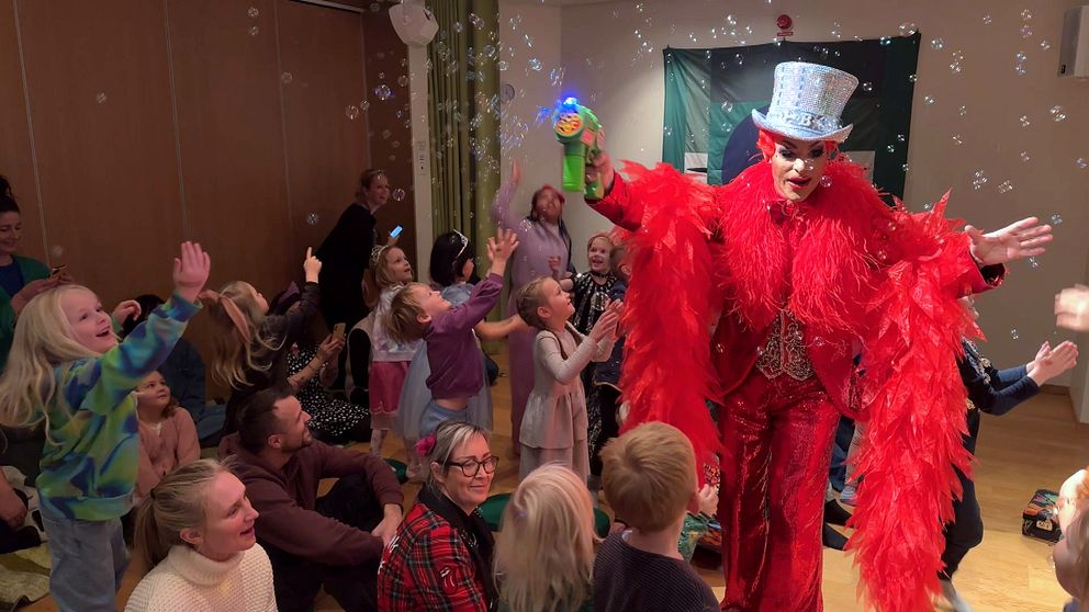 Björta gör såpbubblor framför glada barn.