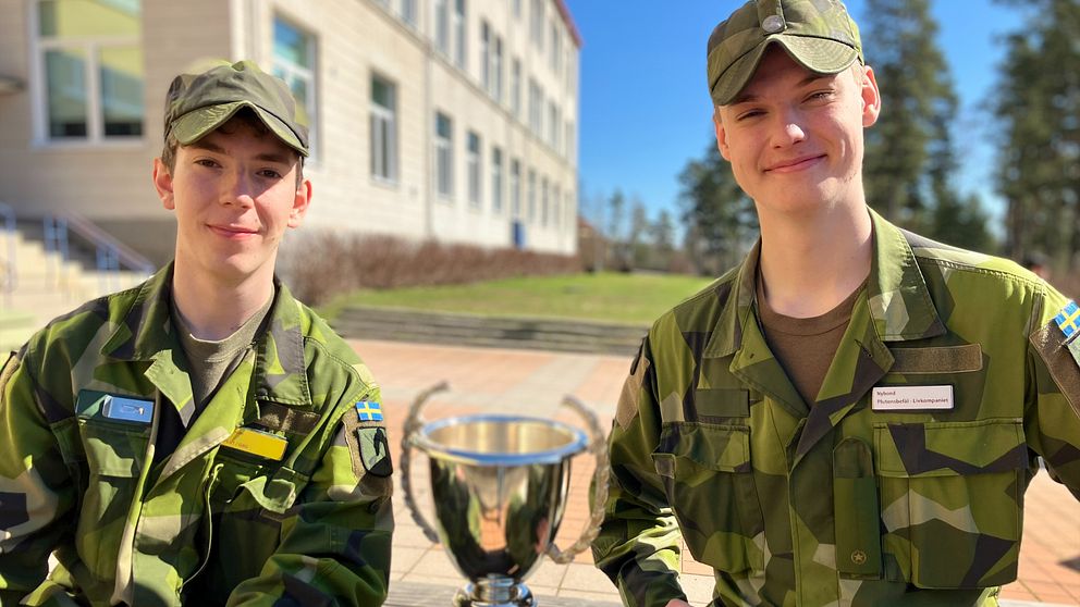 Två värnpliktiga sitter med en pokal