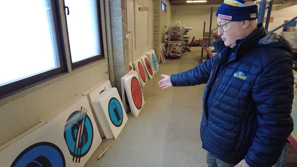 Man pekar på skyltar i rallyförrådet i Umeå