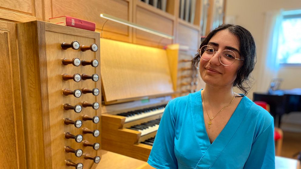 Ung kvinna framför en orgel, när hon ska prata om bristen på kyrkomusiker inom Svenska kyrkan