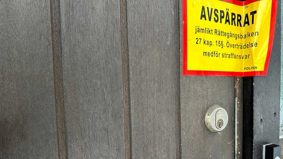 Närbild på en dörr med en avspärrningsskylt.
