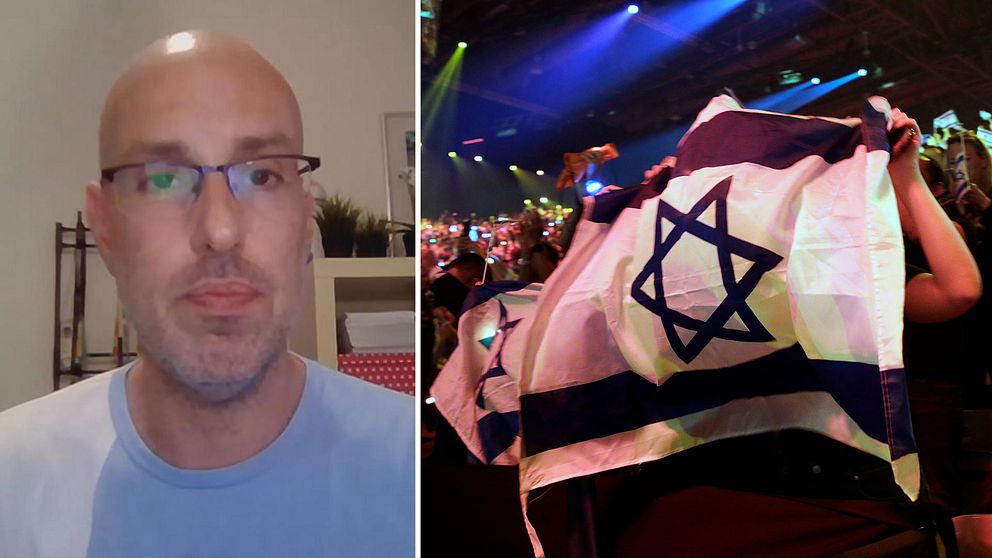Den israeliske Eurovision-experten och tidigare talesmannen 2019för Israels Eurovision-delegation Alon Ami tillsammans med en bild på Israels flagga från Eurovision