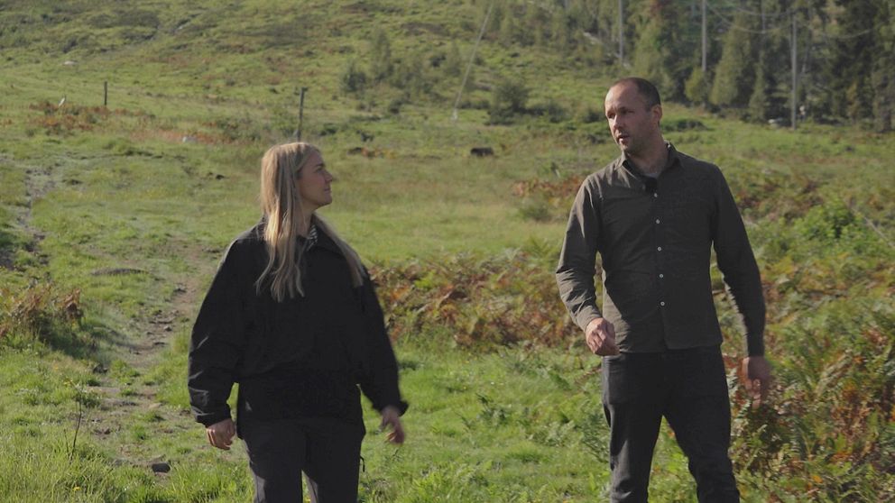 reporter, Greta hansson vikström, och miljömålssamordnare på länsstyrelsen går i en backe i skogen.