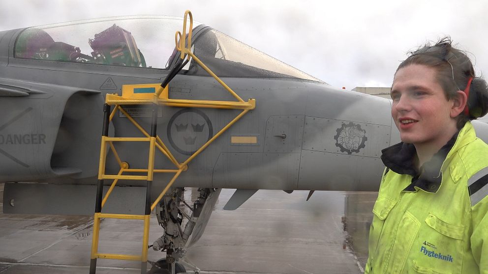Ung man bredvid en JAS-Gripen