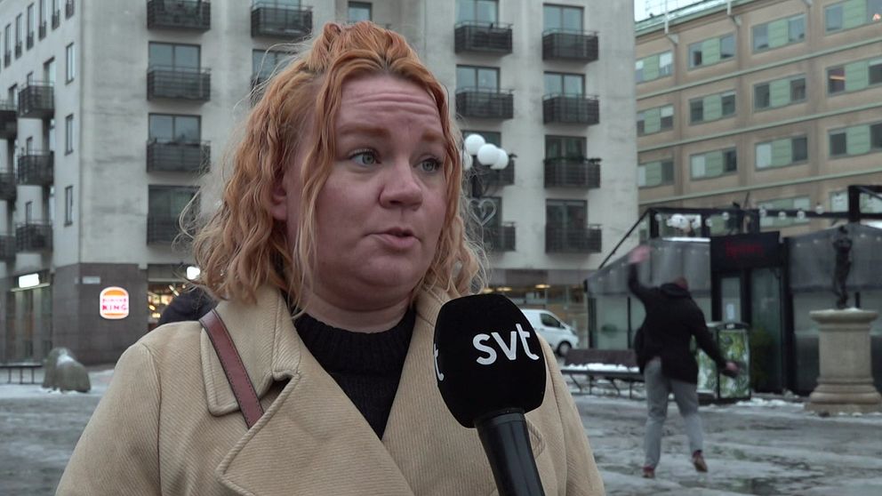 Person halkar i bakgrunden under en intervju.