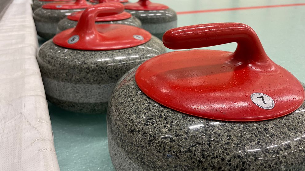 Röda curlingstenar på rad.