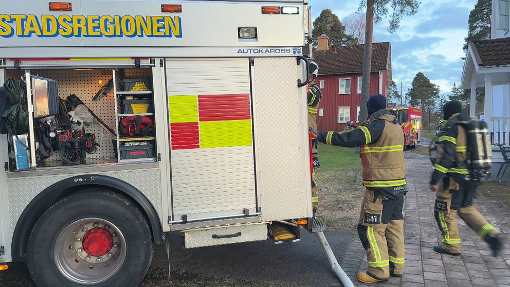 Ett gäng brandmän rör sig kring sitt utryckningsfordon