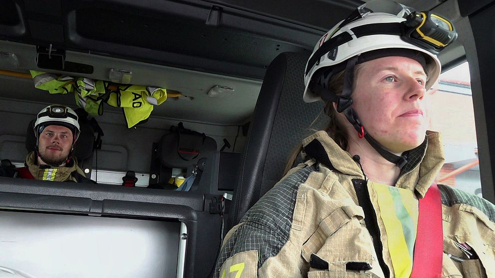 Brandmän i utryckningsfordon iförda hjälmar och skyddskläder.