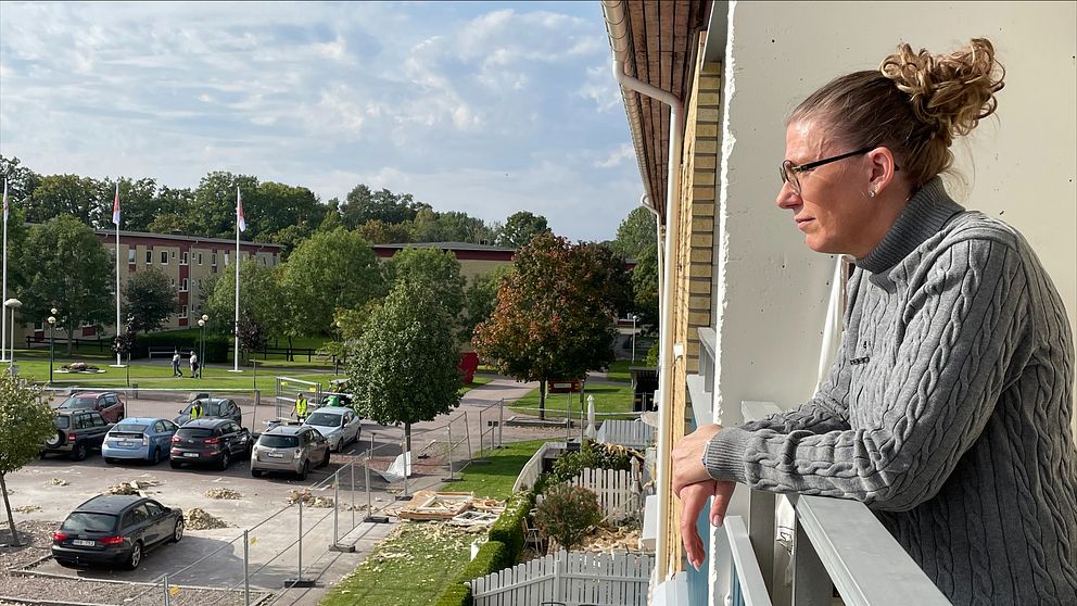 Britt-Louise Malmlöv står i sin balkong och tittar ner. Ekholmen, Linköping.