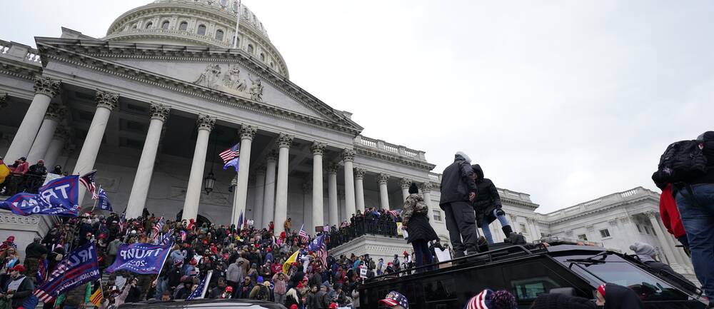 USA:s kongress Kapitolium med folkmassor utanför som försöker ta sig in i byggnaden.