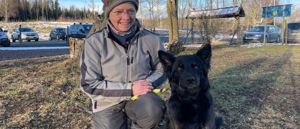 Ingrid Heller och hennes svarta hund.