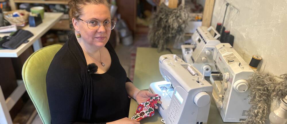 kvinna vid symaskin håller i tygbinda