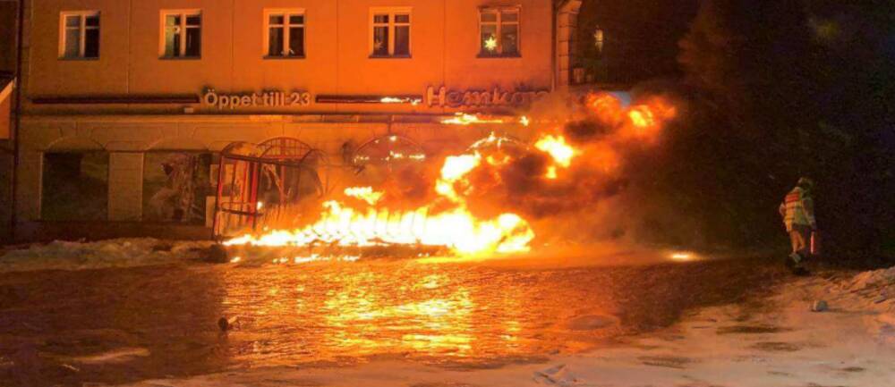 En brand rasar utanför en matvaruaffär och lågorna står höga.