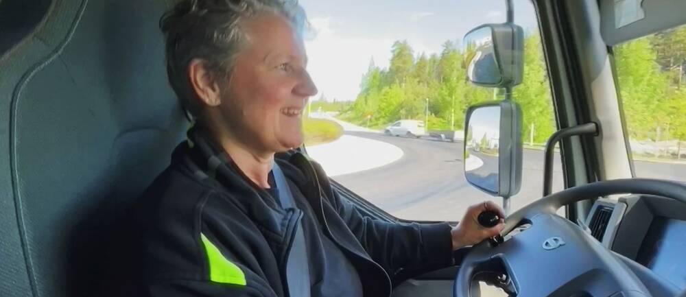 Lillemor från Burträsk, en kvinna i 60-årsåldern, sitter i lastbilen och ser glad ut när hon kör.