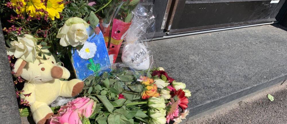 Blommor utanför porten till det bostadshus i Göteborg där en pojke dog efter att ha fallit ner i ett hisschakt.