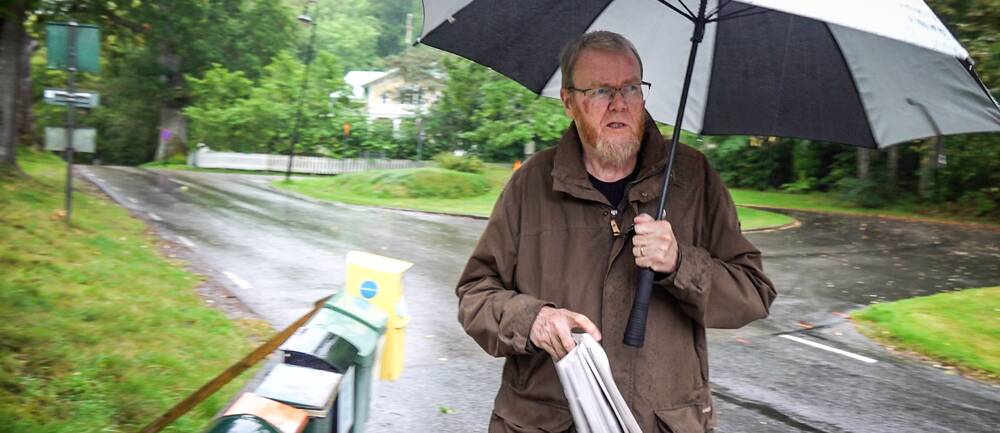 Gunnar Klasson hämtar sin tidning i regnet i Uddevalla.