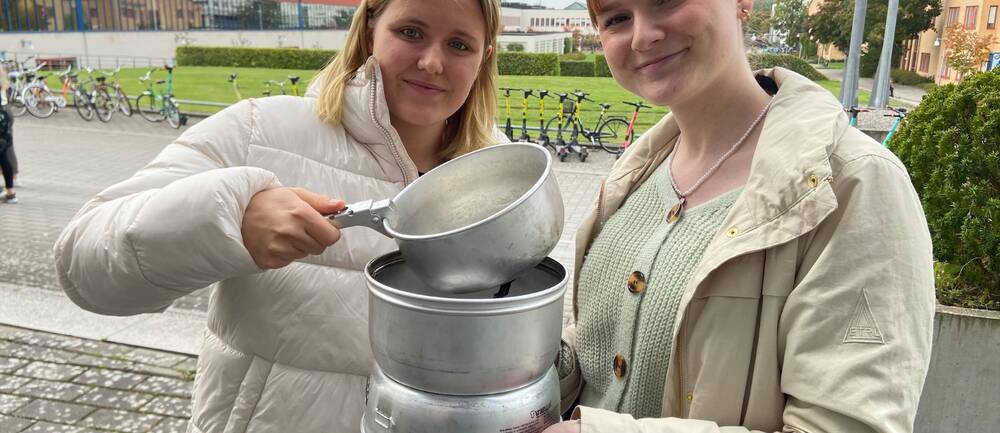 De blivande teaterpedagogerna Tilde Appelqvist och Hanna Hårstad Henriksson håller upp ett ihopsatt spritkök.
