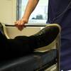 Närbild på ben på en patient som skjutsas i en sjukhussäng av personal i ett sjukhus.