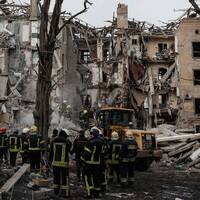 Räddningsarbetare i Donetsk vid ruinerna av ett flervåningshus.
