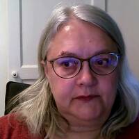 Kvinna med glasögon sitter i en stol. Hon heter Maria Westling Allodi.
