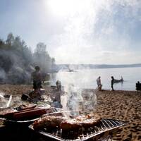 Människor grillar vid vatten.