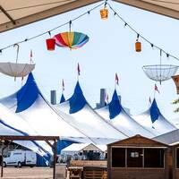 En bild från Frihamnen i Göteborg där man byggt upp blå tält inför Jubileumsfestivalen.